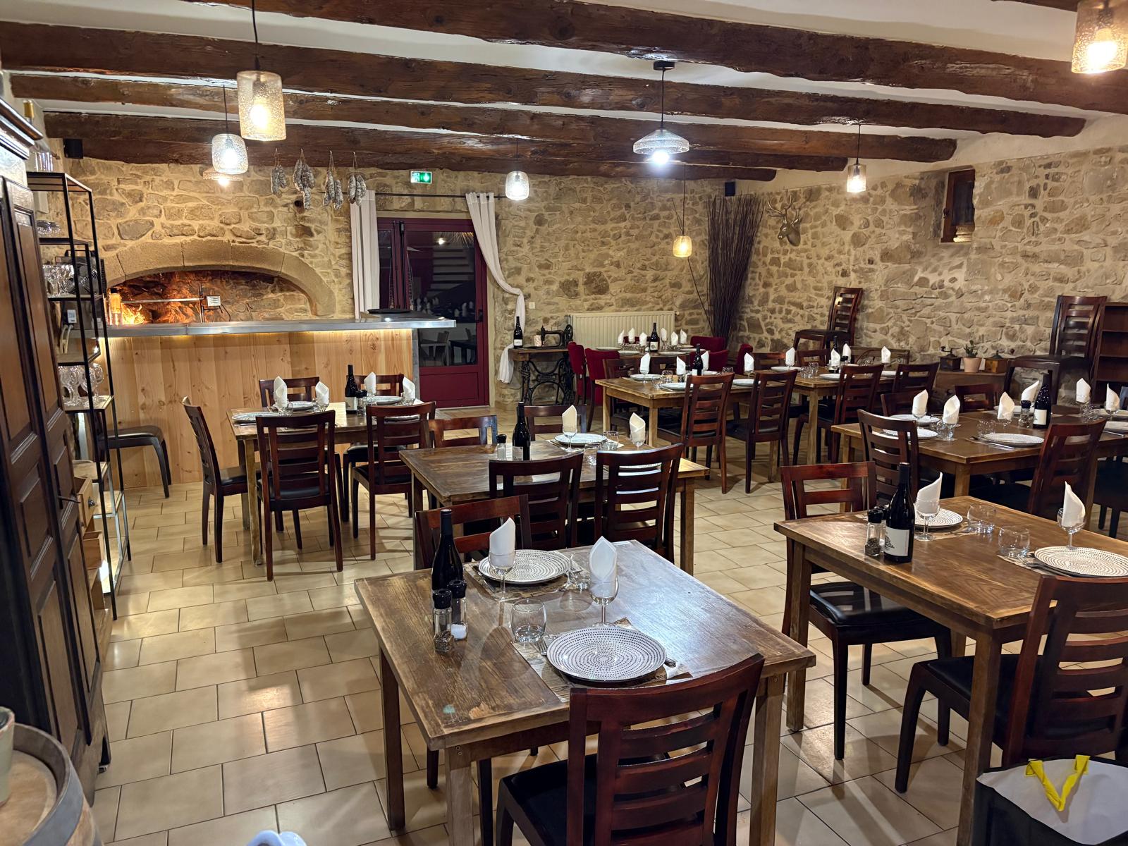 La salle de l’auberge dressée autour de la cheminée