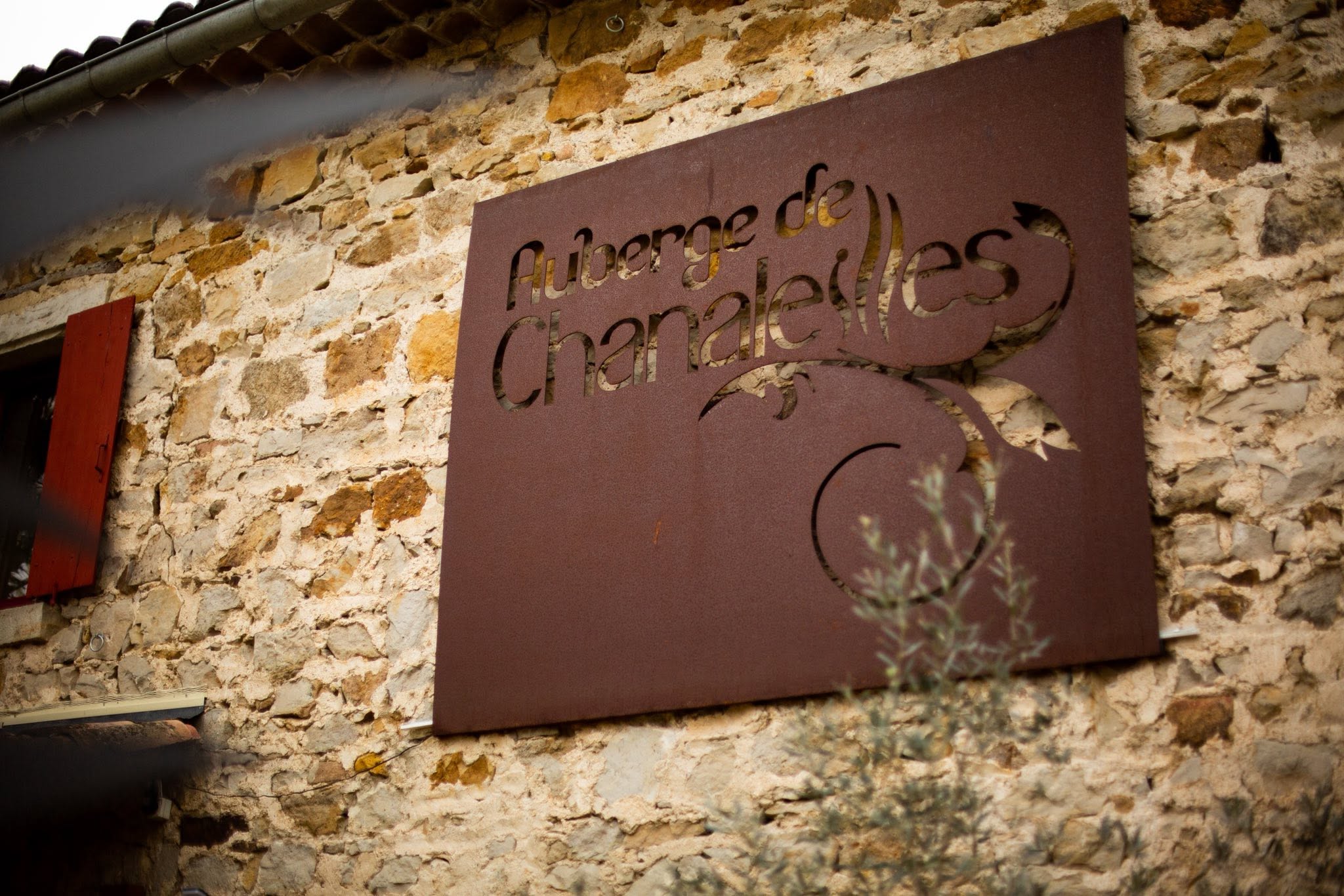 L’enseigne de l’Auberge de Chanaleilles sur le mur en pierre