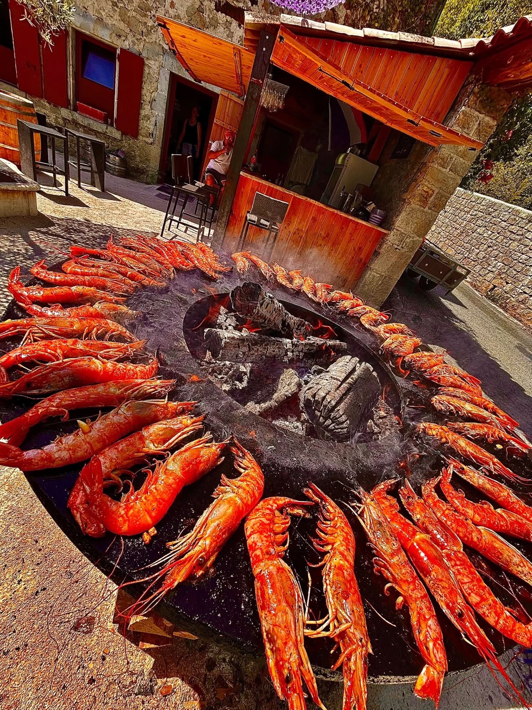 Des gambas disposées autour du brasero